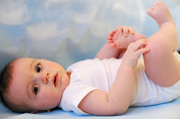 Diapered baby lying on back.