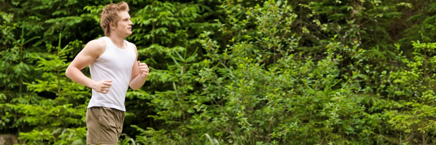 Young man running in forest.