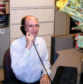 Adam at front desk on phone.